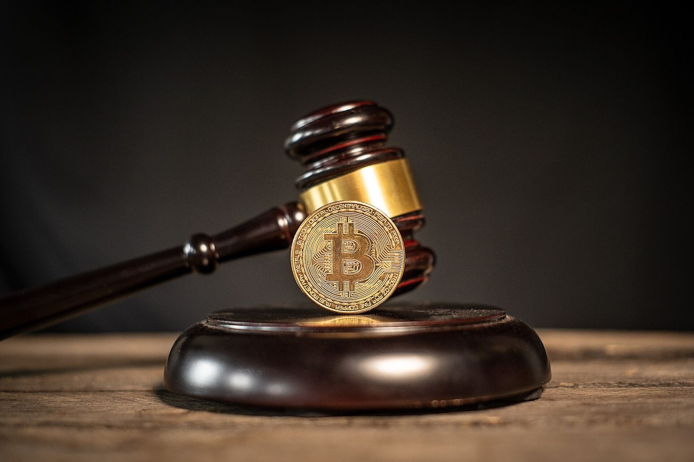 Bitcoin coin resting on cryptocurrency regulation documents